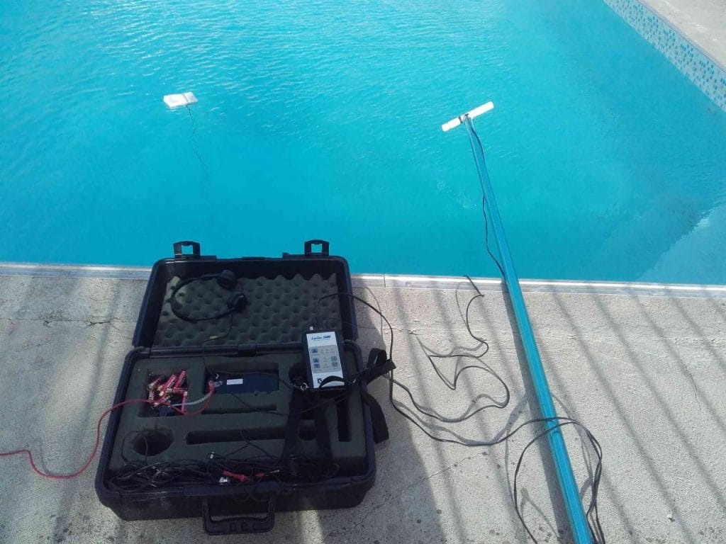 Acoustic sensors and detection equipment deployed in a swimming pool to locate a hidden leak in buried pool plumbing